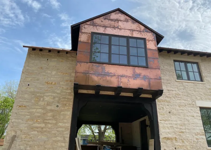 Copper metal panel facade on a stone building for Skylight Installation in Senoia